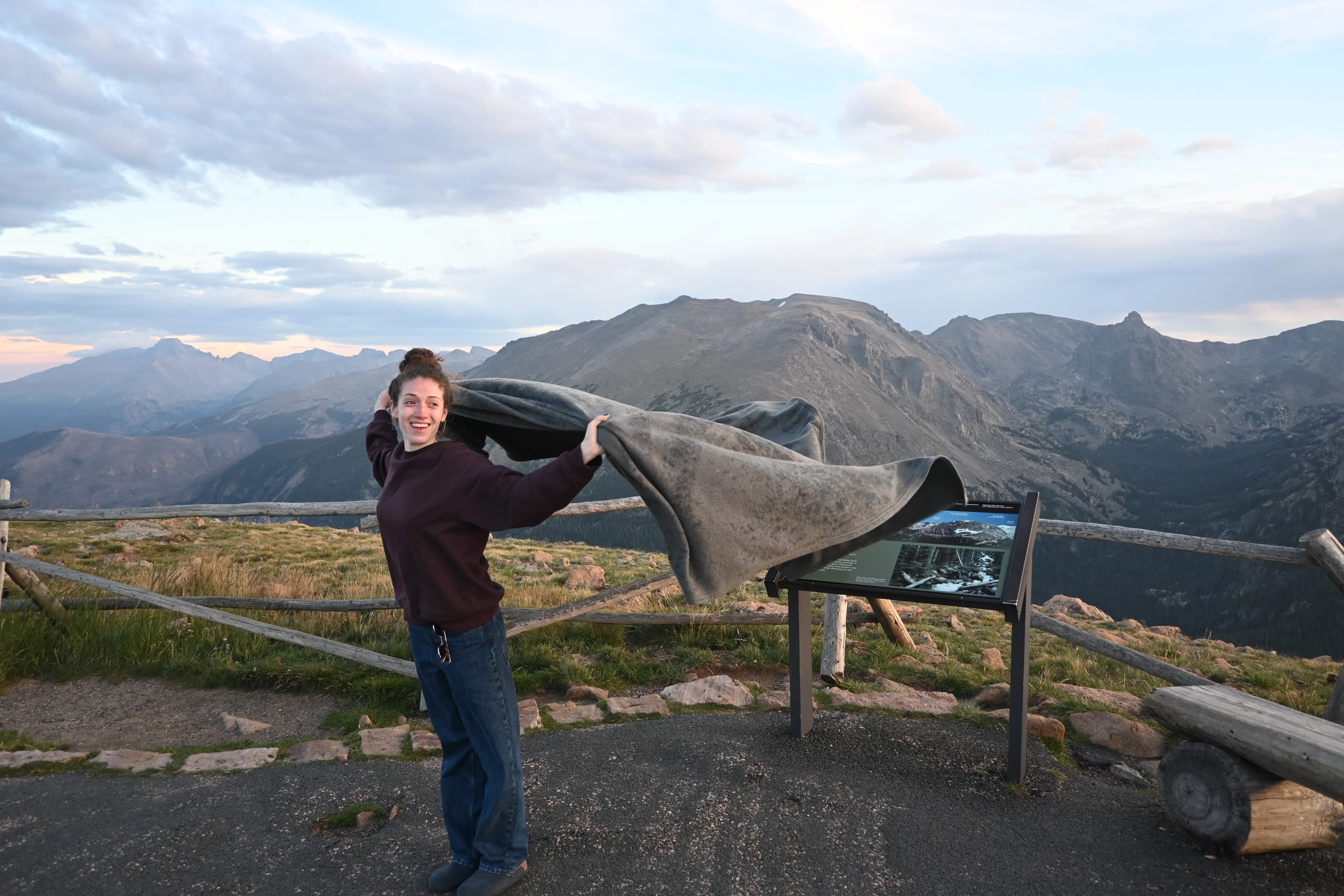 Dóra holding a blanket open at a mountain overlook
